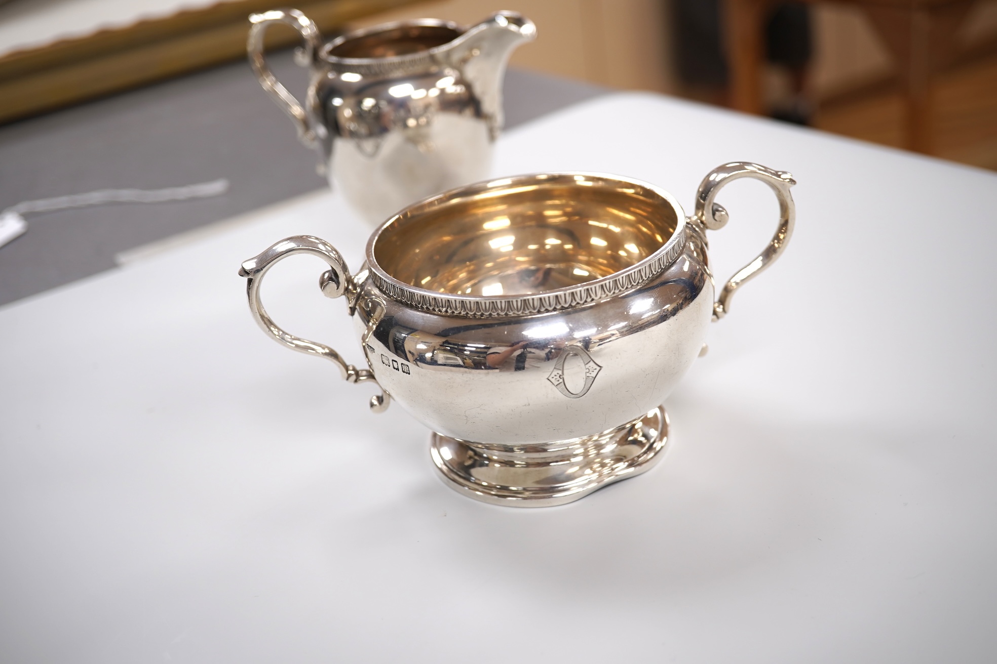 A George V silver circular three piece tea set, with engraved initial, Fenton, Russell & Co Ltd, London, 1927, gross weight 32.4oz.